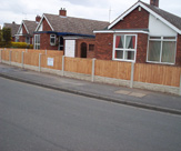 F34 - Concrete slotted posts, rock faced gravel boards and feather edge fence panels
