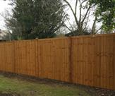 Premium feather edged fence panels with wooden posts and caps.